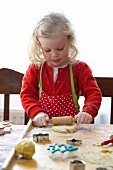 Small girl rolling out dough