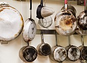 Pots, pans and kitchen utensils hanging on a wall