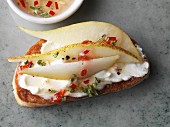 Crostini topped with pears, goats cheese and honey and rosemary marinade