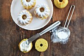 Mini Bundt cakes with cream and icing sugar on a cake stand (seen from above)