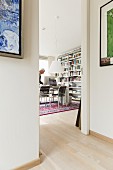 View through open doorway into room with workspace and bookcases against wall