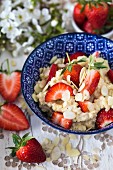 Millet porridge with fresh strawberries and flaked almonds