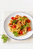Vegetable spaghetti made from kohlrabi with steamed cherry tomatoes and garlic