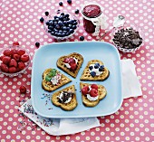 Heart-shaped waffles with berries, jam, chocolate and cream