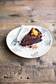 A slice of chocolate cake with candied orange peel