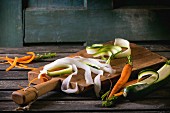 Grated vegetable noodles made from carrots, radishes and courgettes on a chopping board