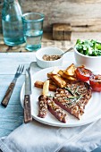 Steak with grilled tomatoes, chips and salad