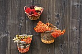 Baskets filled with berries and flowers hung on wooden wall