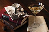 A dry martini with olives and classic books in a den