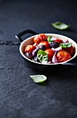 Oven-roasted tomatoes with olives, garlic cloves and basil