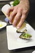 Oysters being drizzled with lemon juice