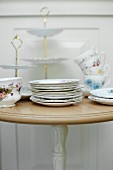 Vintage crockery (plates, cups and a cake stand) on a table