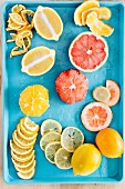 An arrangement of freshly cut lemons, Meyer lemons and grapefruits on a turquoise tray