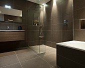 Hängewaschtisch neben begehbarer Dusche in puristischem Designerbad mit graubraunen, grossformatigen Fliesen