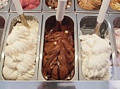 Various types of ice cream in metal containers in an ice cream parlour