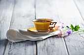 A yellow coffee cup on a napkin with flowers