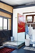 Rustic shower area with vintage advertising sign on glass screen in bathroom