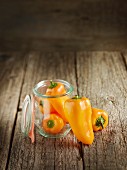 Fresh orange pepper in and next to a preserving jar