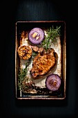 Roasted pork chop with red onions, garlic and rosemary