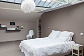 Minimalist attic bedroom with glass ceiling and taupe walls