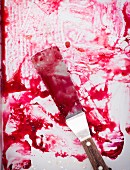 A baking tray and a palette knife smeared with plum juice