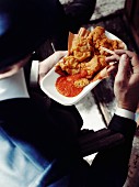 Mann isst frittierte Clams (Dinner im Stil der 1920er Jahre, USA)