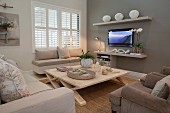 Scandinavian wooden table and window seat in seating area with flatscreen TV