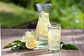 Elderflower juice with lemons and elderflowers on a wooden table