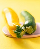 Yellow and green courgettes on a ceramic board