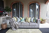 Grey sofa with scatter cushions in loggia