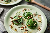 Homemade spinach ravioli with roasted pine nuts