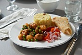 Chicken curry with peas, tomato salad and rice (South Africa)