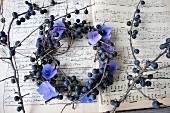 Kranz aus blauen Hortensienblüten & Schlehenbeeren auf nostalgischem Notenpapier