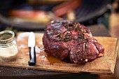 Grilled steak with herbs on a chopping board