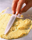 Polenta being spread with a knife