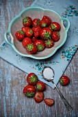 Erdbeeren und Löffel mit Zucker