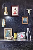 Schwarz gestrichene OSB-Platten an Wand und Küchenschränken, Ikonenbilder und Pendelleuchten