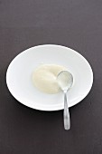 Bechamel sauce on a plate with a spoon