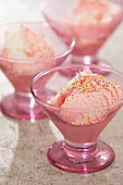 Pink dessert bowl of ice cream decorated with sugar sprinkles