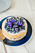 Blueberry cake with mascarpone and blueberry cream and pansies