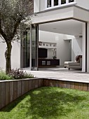 View from garden across terrace into modern living room