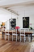 Long wooden table and vintage wooden chair in open-plan living area