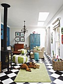 Log-burner, chequered floor and dog lying on rug in living room