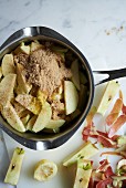 Apple wedges with spices in a pot (ingredients for apple pie)