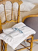 Lace-edged pillowcases tied with satin ribbon on wooden chair