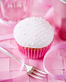 A cupcake with white fondant glaze