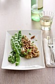 A fish fillet with tahini sauce, walnuts and a bean medley