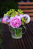 Posy of roses (variety ' Princess Alexandra'), mallow and lady's mantle in small, glass teapot