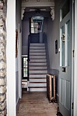 Wooden staircase in rustic foyer seen through front door