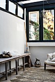 Rustic wooden bench against wall below strip of transom windows